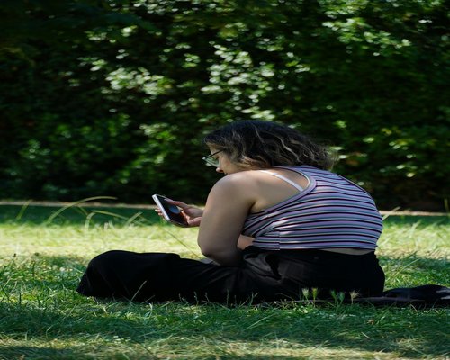 Relaxed woman checking smartwatch in park